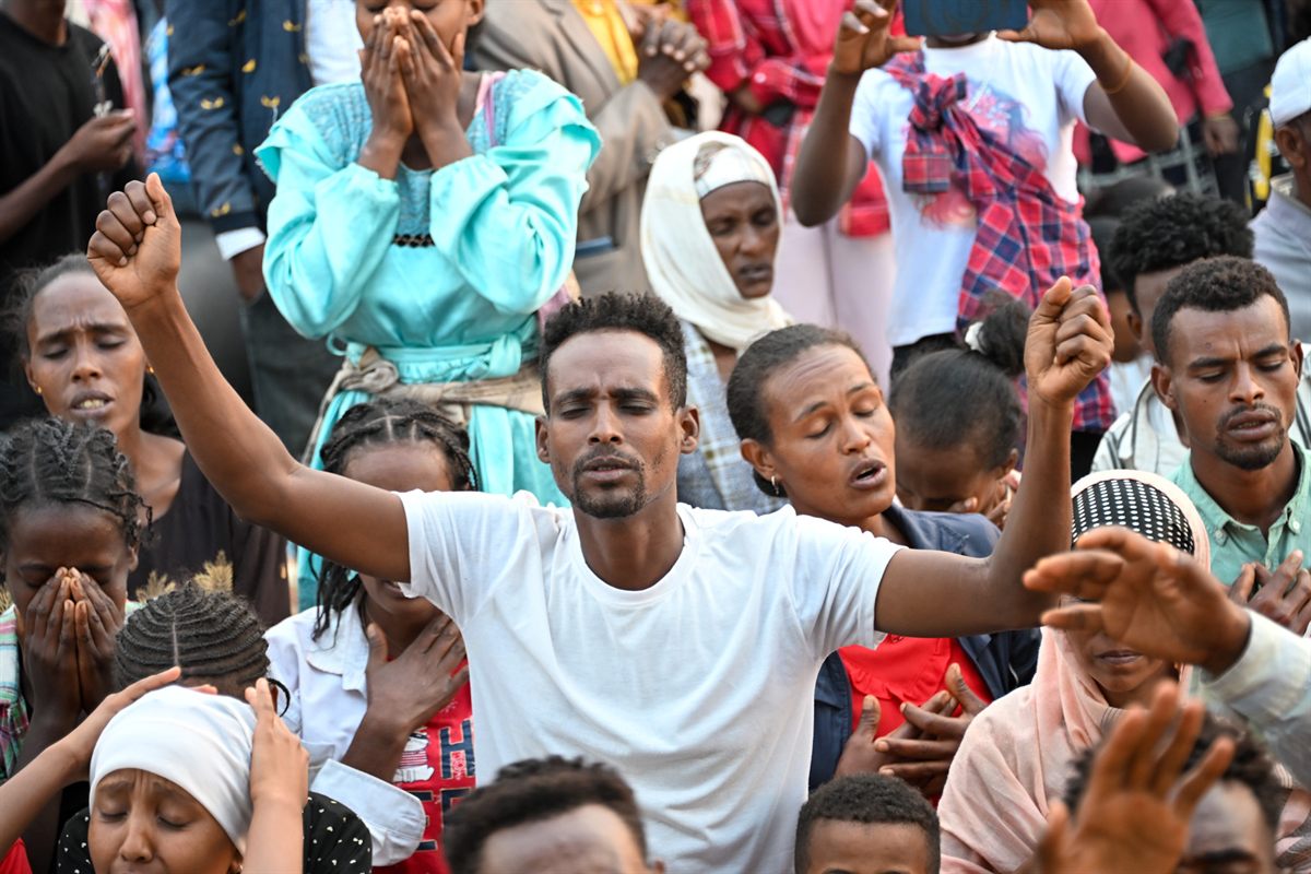 People worshipping with raised hands